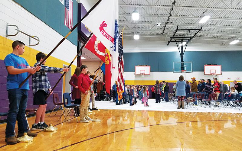 Colton Berrong, Samuel Henry, Isaiah Matheson, Molly Ledford, Gabriella Ermosos and Levi Chastain present the flags as veterans and their families enter the Martins Creek School gym Tuesday morning.