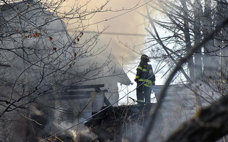 A firefighter observes a burning home at 41 Ramsey Estates in Murphy on Feb. 21.