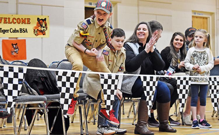 Ethan Reeves jumps for joy as his car comes in first place during the Nantahala District of Cub Scouts’ Pinewood Derby on March 1.