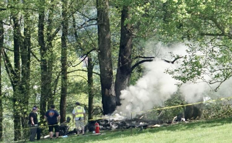 Emergency responders keep watch over the smoldering remains of a small airplane that crashed in Cherokee County, North Carolina, on Saturday, April 15.